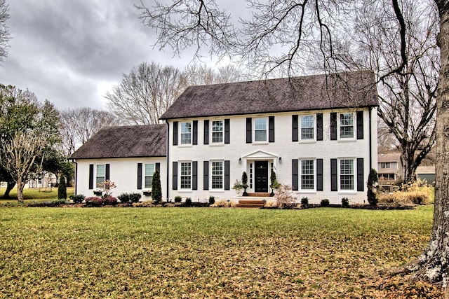 colonial-style house featuring a front lawn