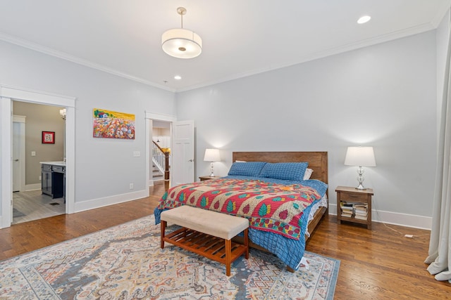 bedroom featuring dark hardwood / wood-style flooring, connected bathroom, and crown molding