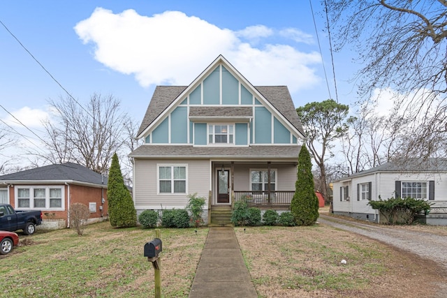 tudor house featuring a front yard and covered porch