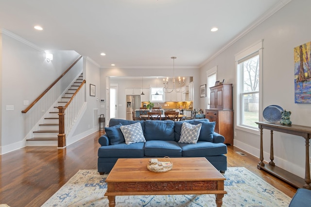 living room featuring an inviting chandelier, hardwood / wood-style flooring, and ornamental molding