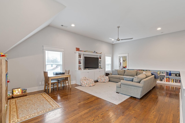 living room with dark wood-type flooring, ceiling fan, and vaulted ceiling