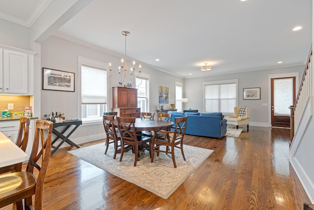 dining space with a notable chandelier, ornamental molding, and dark hardwood / wood-style floors