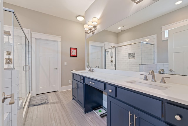 bathroom with a shower with door and vanity