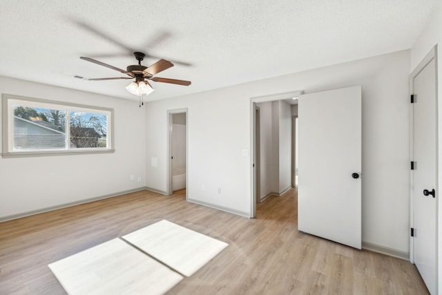 unfurnished bedroom featuring ceiling fan, light hardwood / wood-style floors, and a textured ceiling