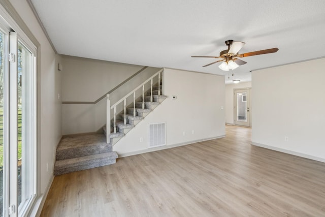 interior space featuring ceiling fan, a textured ceiling, and light wood-type flooring