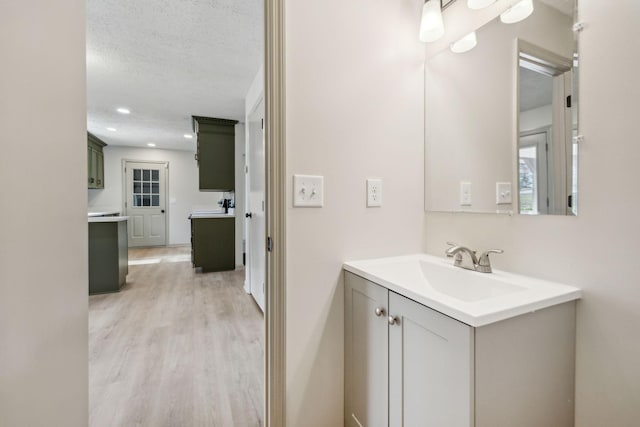 bathroom with vanity, hardwood / wood-style flooring, and a textured ceiling