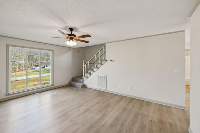 unfurnished room with ceiling fan, light hardwood / wood-style flooring, and a textured ceiling