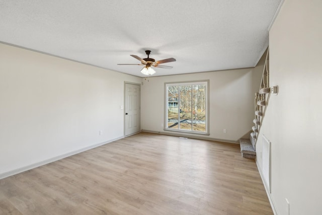 unfurnished room featuring ceiling fan, light hardwood / wood-style flooring, and a textured ceiling