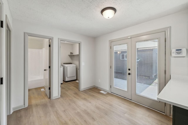 entryway featuring french doors, plenty of natural light, light hardwood / wood-style floors, and a textured ceiling