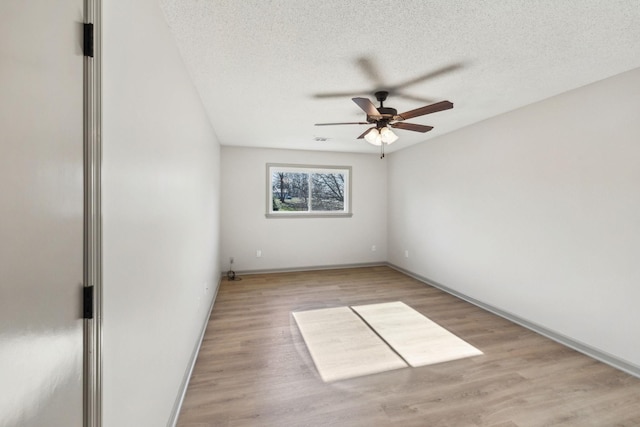 empty room featuring ceiling fan, a textured ceiling, and light wood-type flooring