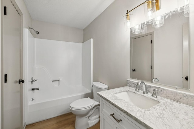 full bathroom featuring vanity, hardwood / wood-style flooring, bathing tub / shower combination, and toilet