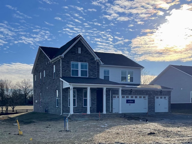 view of property featuring covered porch and a garage