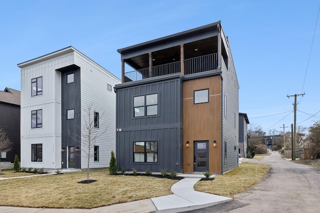 view of front of property with a balcony and a front yard