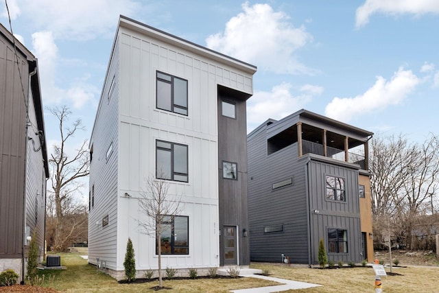 exterior space featuring a balcony, central AC unit, and a lawn