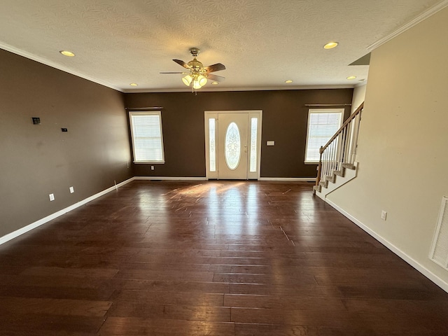 entryway with crown molding, dark wood-type flooring, and a textured ceiling