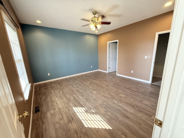 empty room featuring hardwood / wood-style flooring, a textured ceiling, and ceiling fan