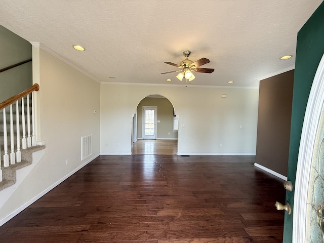 empty room with ornamental molding, dark hardwood / wood-style floors, a textured ceiling, and ceiling fan