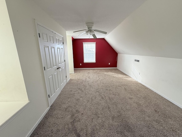 bonus room featuring lofted ceiling, carpet floors, and ceiling fan