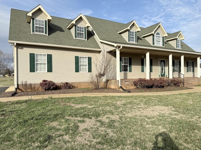 new england style home with covered porch and a front lawn