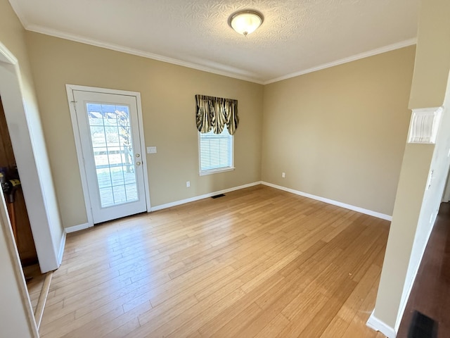 interior space with ornamental molding, light hardwood / wood-style floors, and a textured ceiling