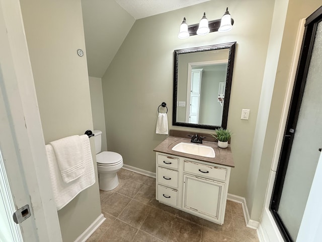 bathroom with vanity, vaulted ceiling, tile patterned floors, and toilet