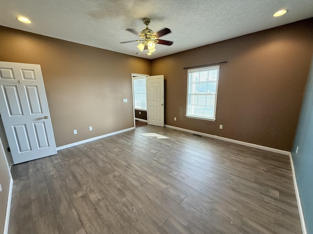 unfurnished bedroom featuring wood-type flooring, ceiling fan, and a textured ceiling