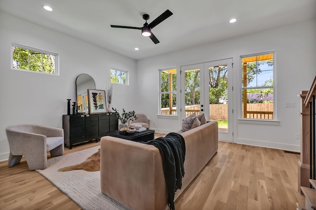 living area with french doors, ceiling fan, and light wood-type flooring