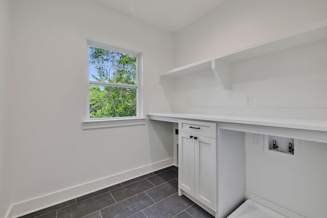 laundry room featuring cabinets and dark tile patterned flooring