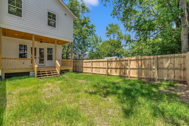 view of yard featuring ceiling fan and a deck