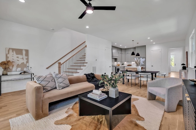 living room with ceiling fan and light hardwood / wood-style flooring