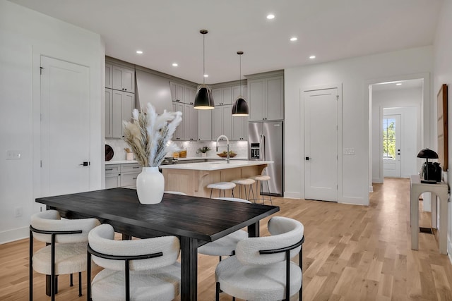 dining room with sink and light wood-type flooring