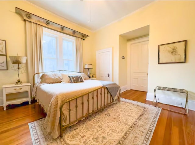 bedroom featuring wood-type flooring and ornamental molding