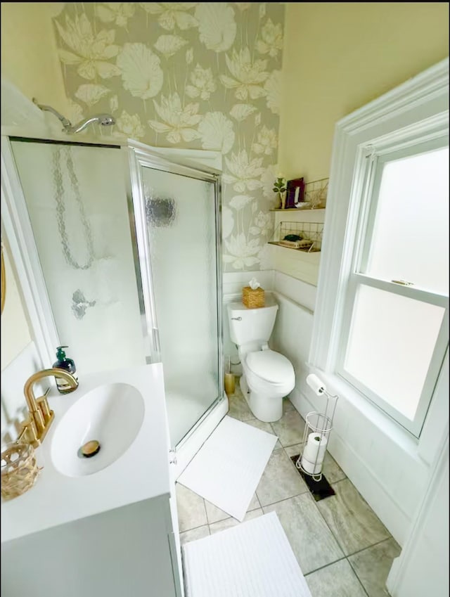 bathroom featuring a shower with door, sink, tile patterned floors, and toilet