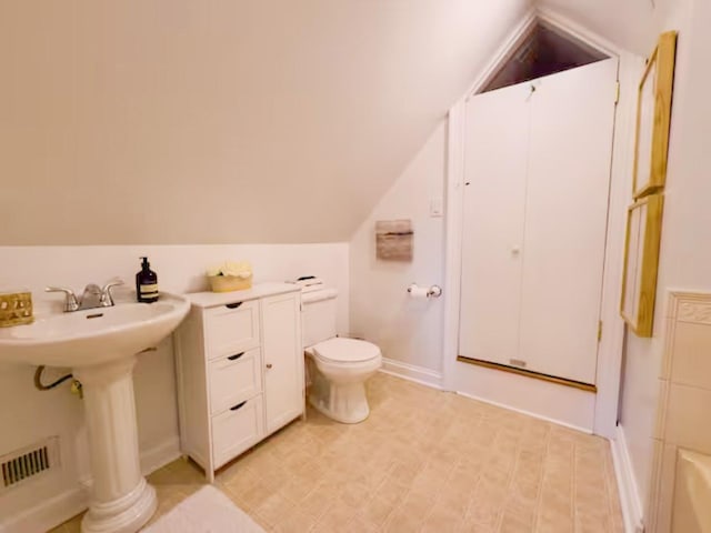 bathroom featuring toilet and vaulted ceiling