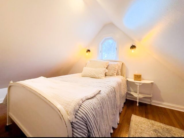 bedroom featuring dark wood-type flooring and vaulted ceiling