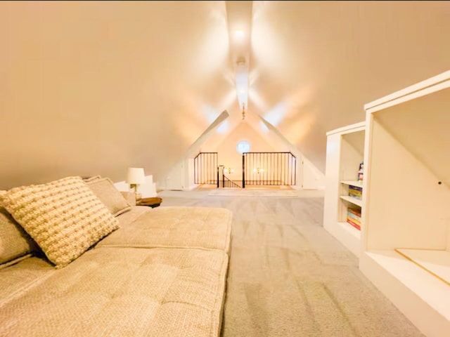 additional living space featuring built in shelves, carpet, and vaulted ceiling with beams