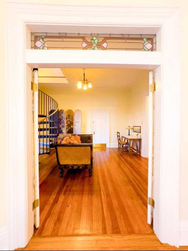 hall with hardwood / wood-style flooring and an inviting chandelier