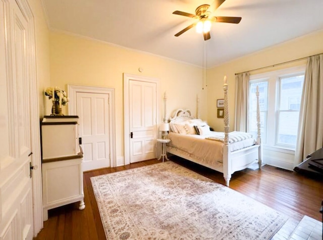 bedroom with crown molding, dark wood-type flooring, and ceiling fan