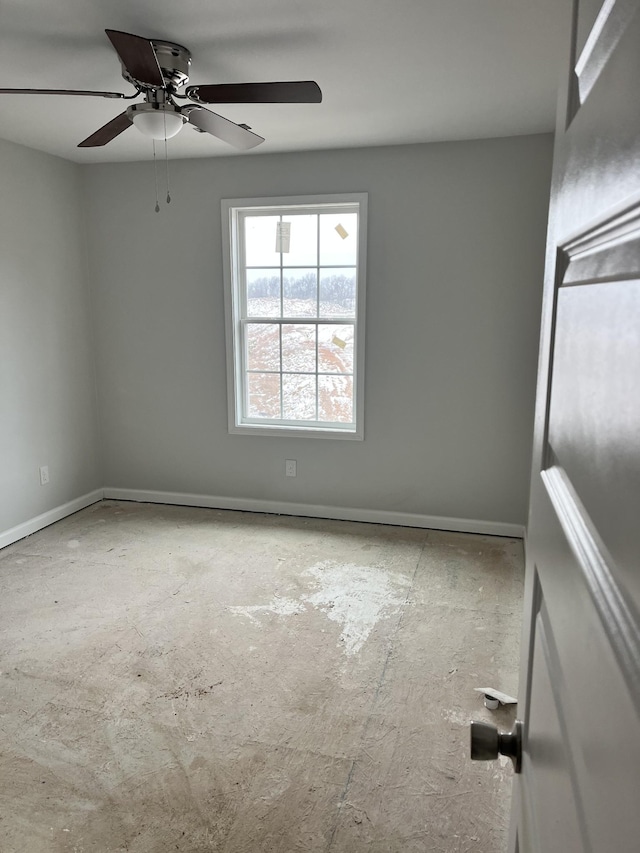 unfurnished room featuring a ceiling fan and baseboards