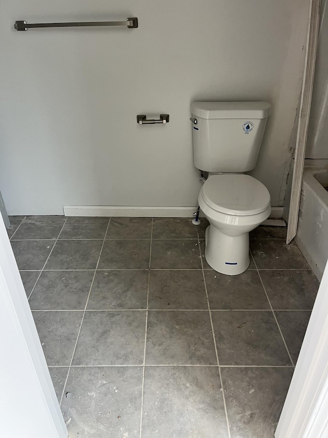 bathroom featuring toilet, baseboards, and tile patterned floors