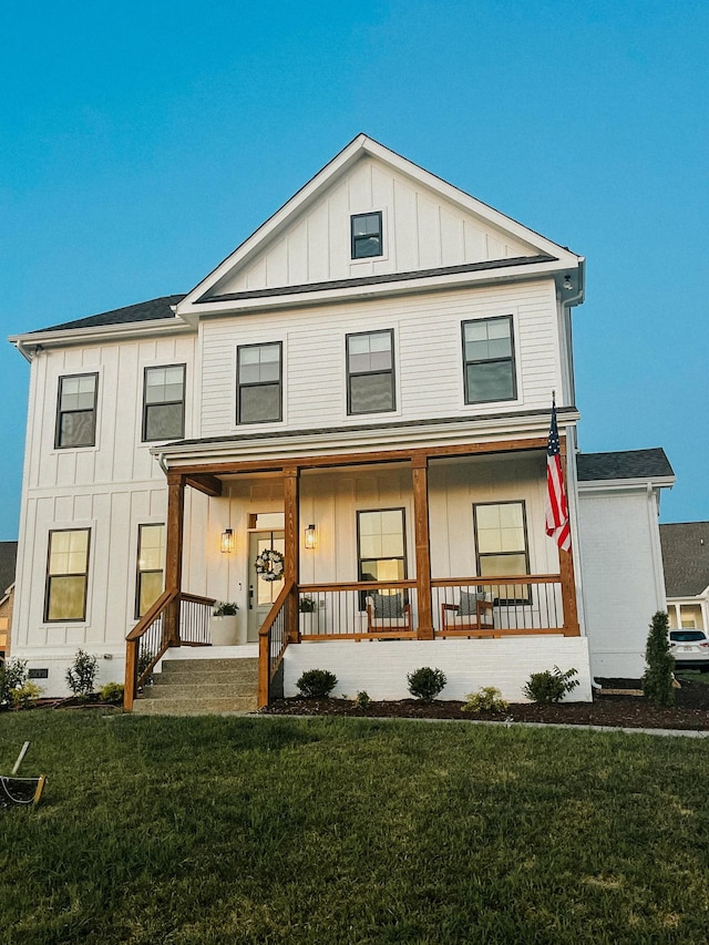 view of front of house featuring a porch, board and batten siding, and a front yard