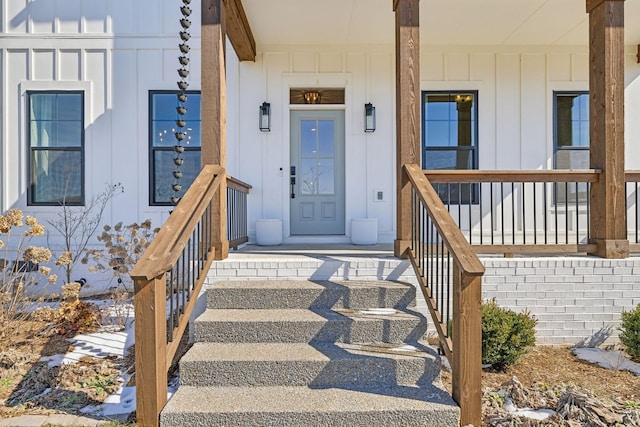 entrance to property with covered porch and board and batten siding