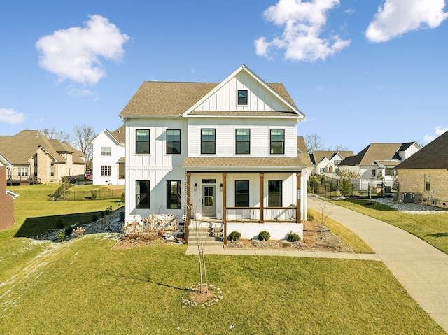 modern farmhouse style home featuring board and batten siding, covered porch, a shingled roof, and a front lawn