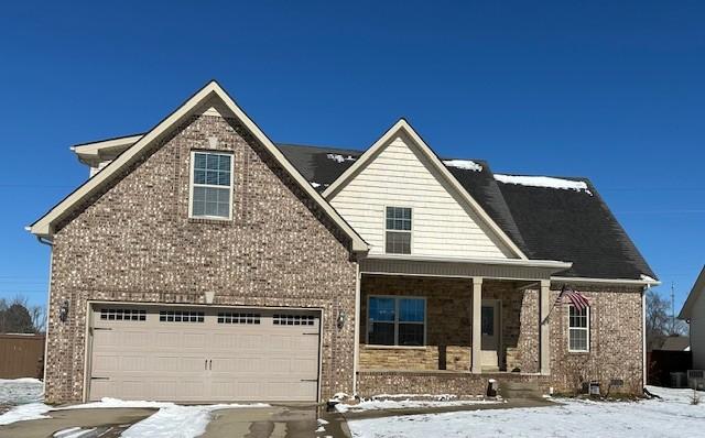 view of front of home with a porch, brick siding, and an attached garage