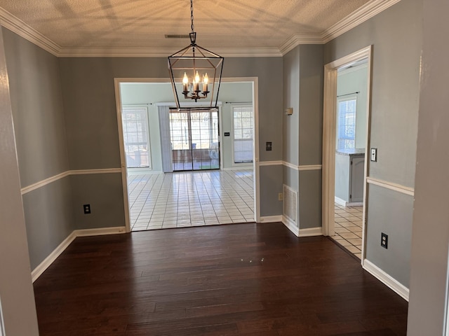 unfurnished dining area with crown molding, dark hardwood / wood-style floors, and an inviting chandelier