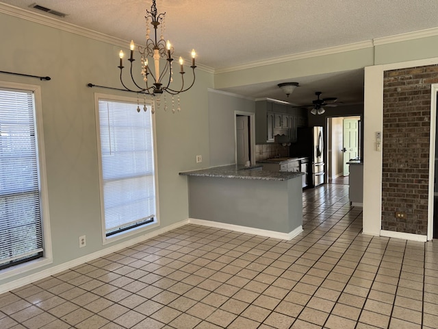 kitchen featuring light tile patterned floors, plenty of natural light, ornamental molding, and kitchen peninsula