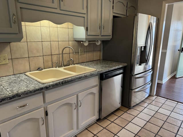 kitchen with gray cabinetry, sink, tasteful backsplash, and appliances with stainless steel finishes