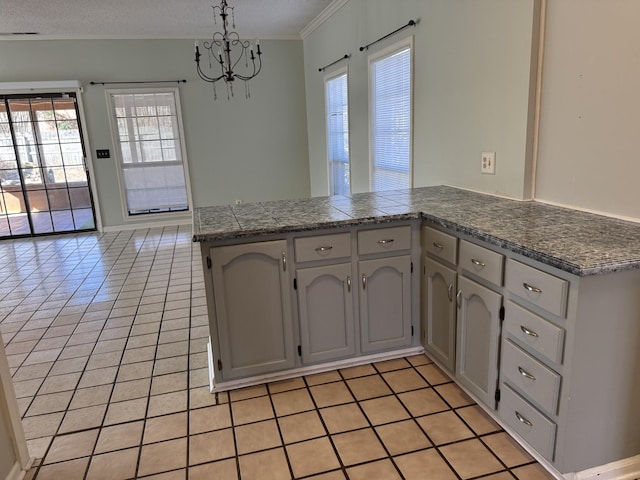 kitchen featuring pendant lighting, light tile patterned floors, crown molding, and kitchen peninsula