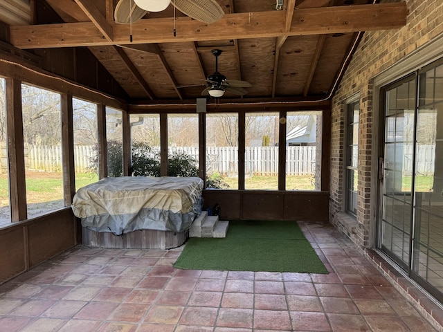 unfurnished sunroom with ceiling fan and vaulted ceiling with beams
