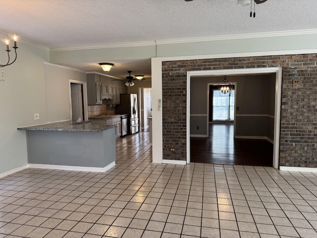 kitchen with tile patterned floors, stainless steel fridge with ice dispenser, a textured ceiling, brick wall, and ceiling fan with notable chandelier